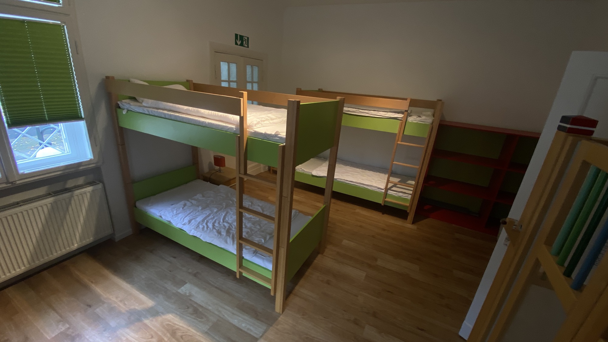 Mehrbettzimmer mit gr&uuml;nen Etagenbetten