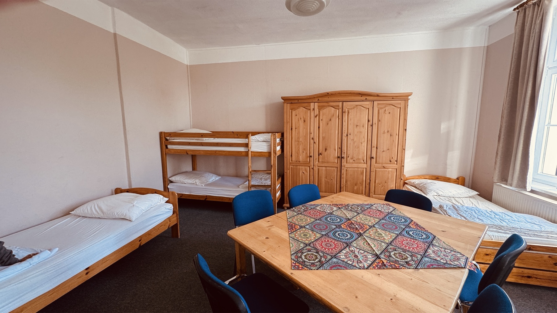 Mehrbettzimmer mit Etagenbett und Einzelbetten