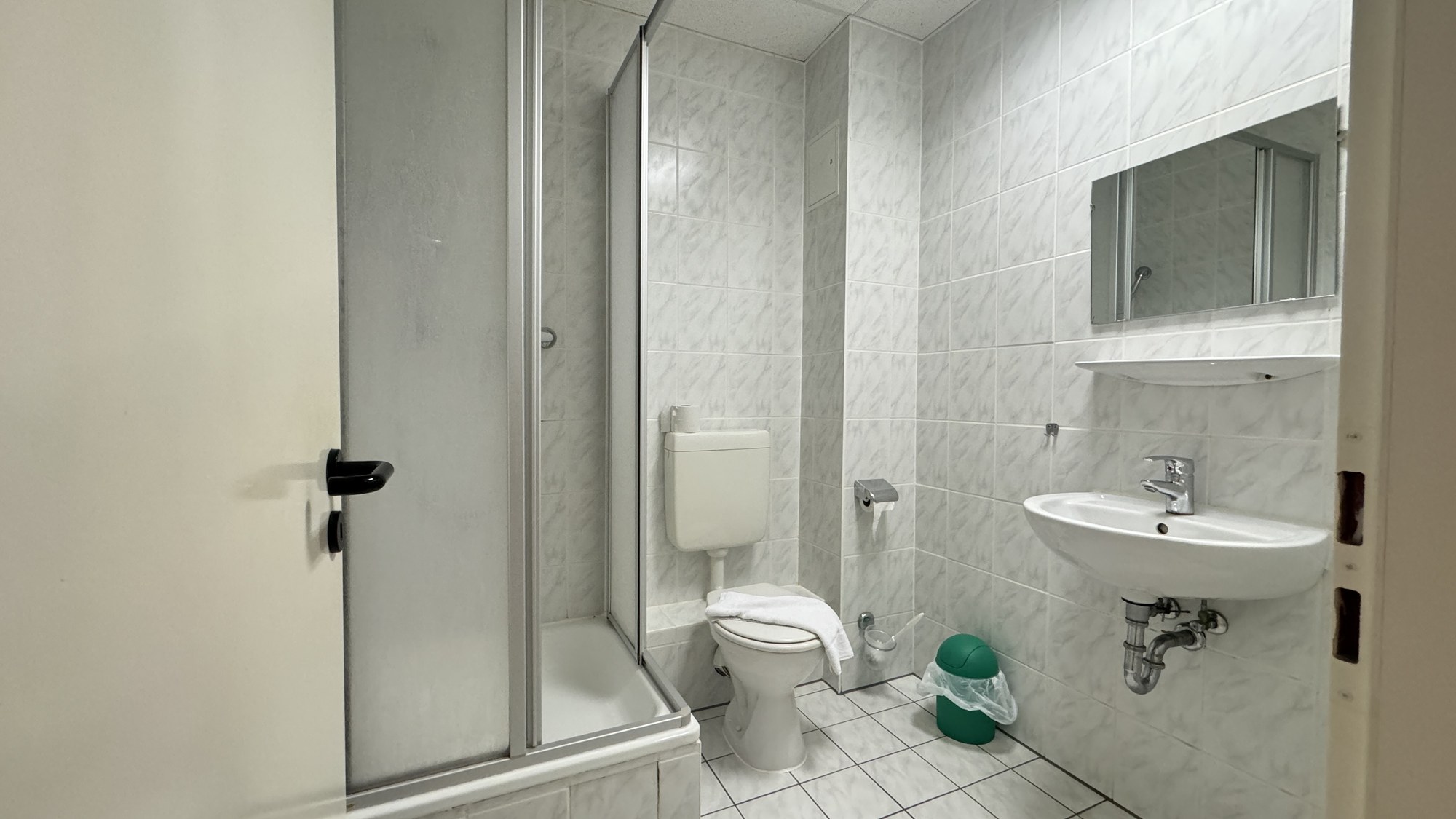 Gefliestes Bad mit Dusche, WC und Waschbecken