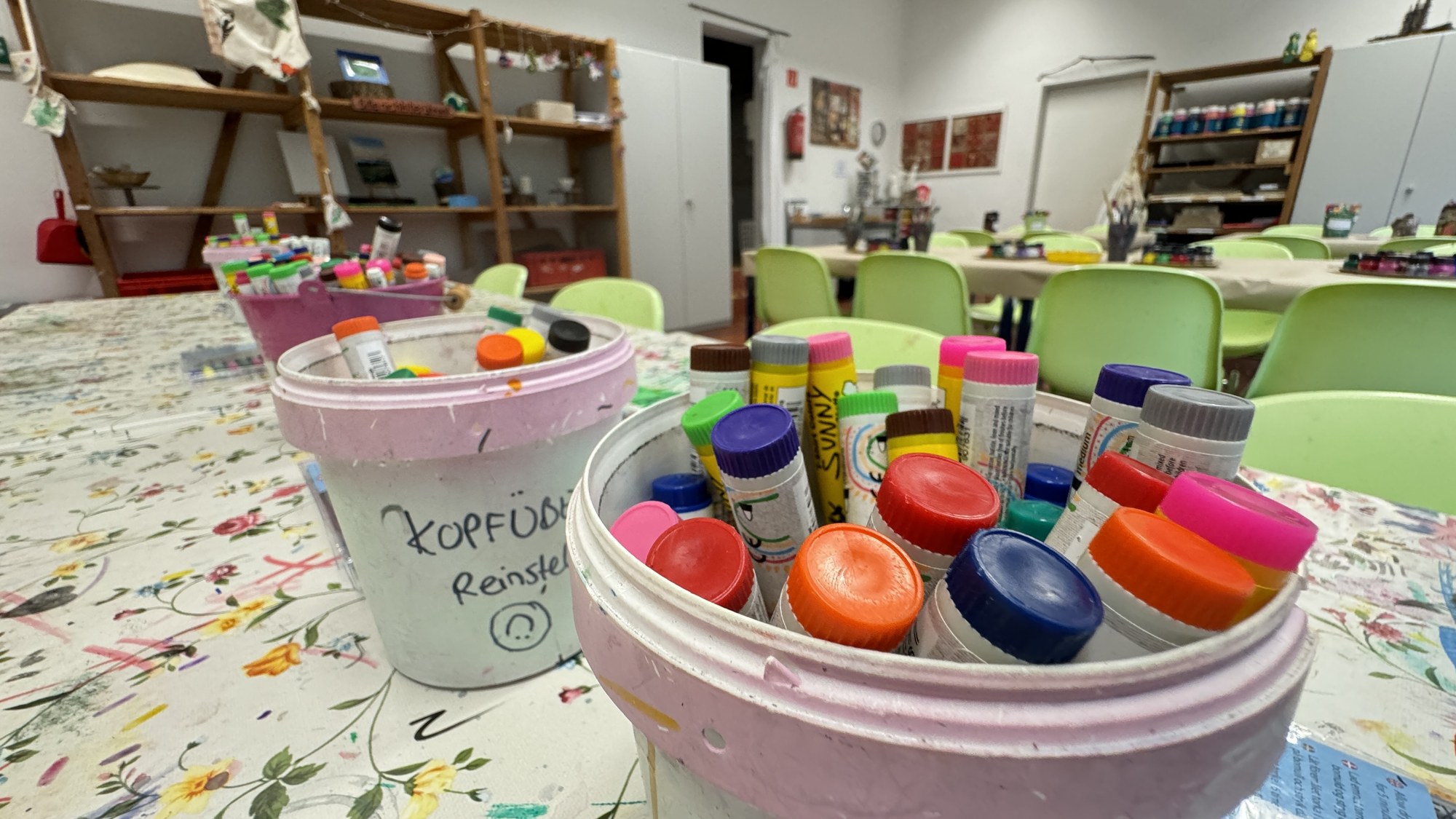 Kreativraum mit Tischen, Farben und Bastelmaterialien
